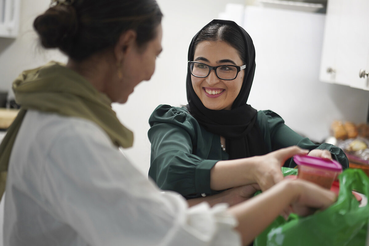 Maryam Rahimi and Marjila Badakhsh prepare food for a neighbor and fellow Afghan refugee at their apartment
