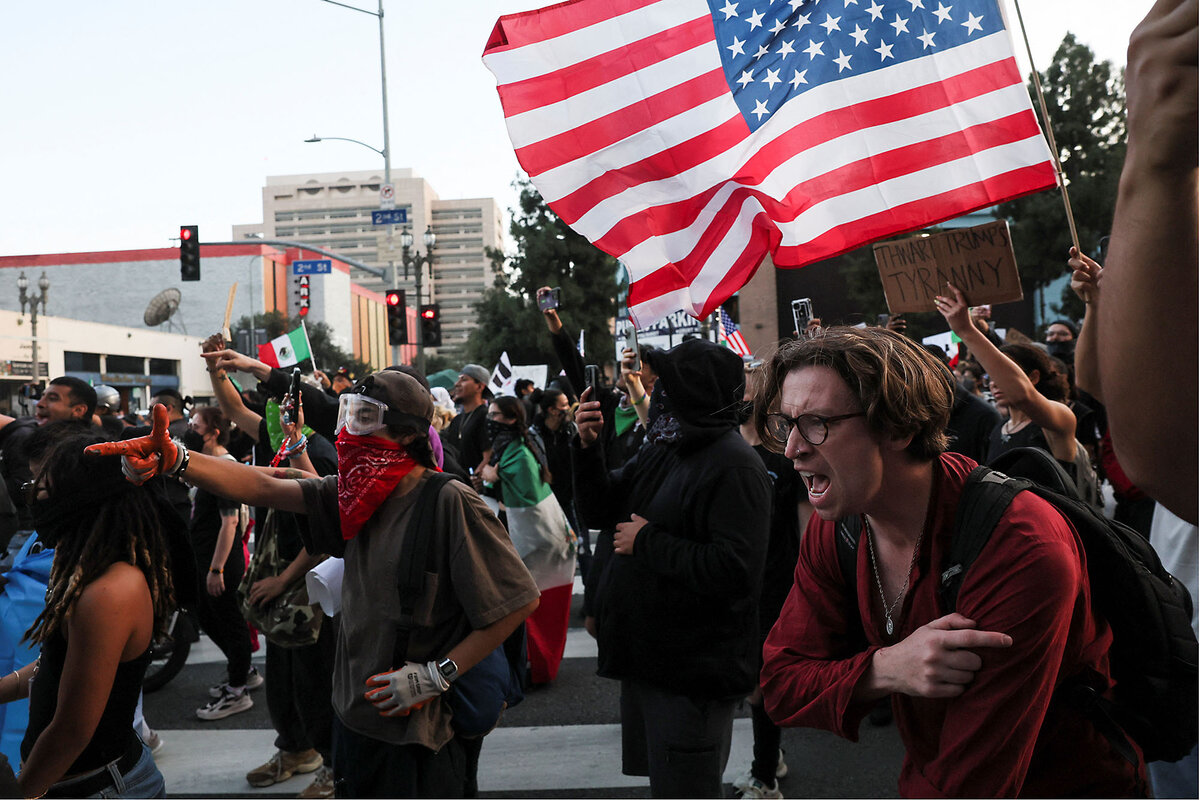 Demonstrators holding an American flag rush forward after being shot at during protests against federal immigration sweeps.